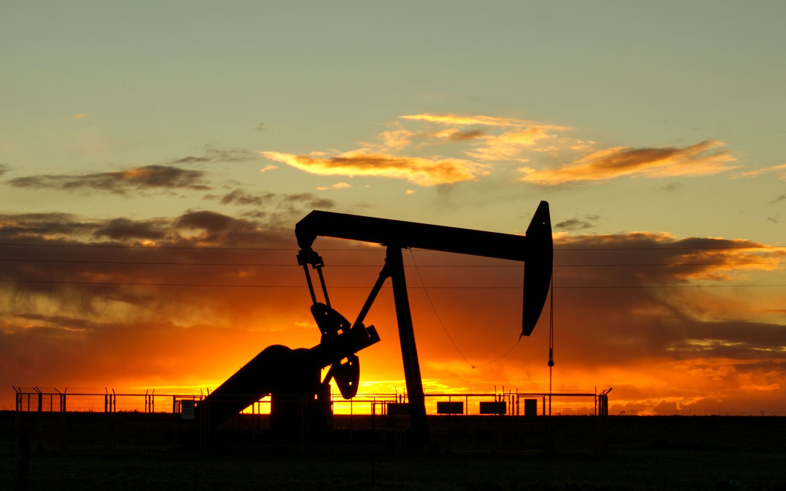 Oil pumpjack silhouetted at sunset